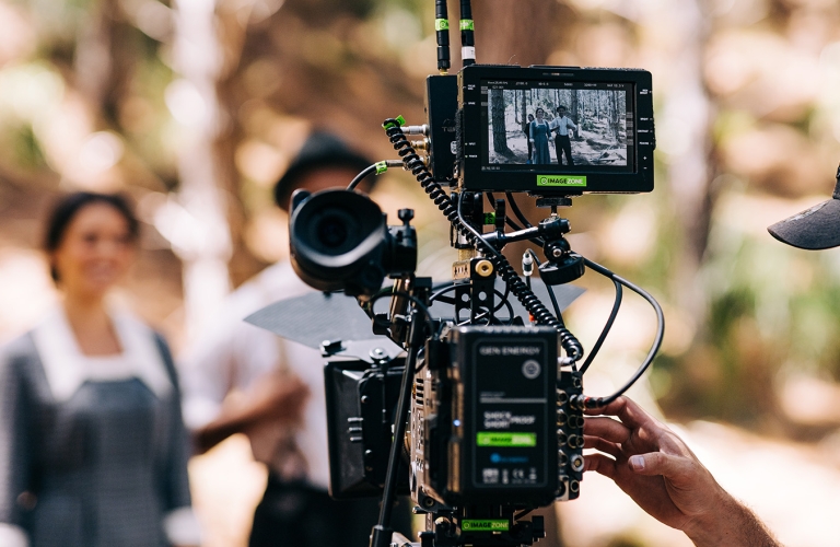 Close up look of a camera filming actor and actress